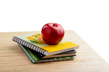 School teacher's desk with stack of books and apple