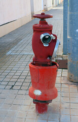 Fototapeta na wymiar Red fire hydrant faucet on the street close-up, fire fighting, fire safety, Spain