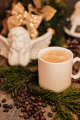 Christmas composition angel, cup of coffee on a dark wooden table