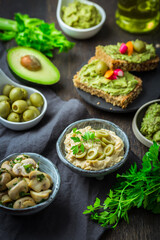 Vegan raw food snacks with fresh juicy vegetables, avocado dip and humus