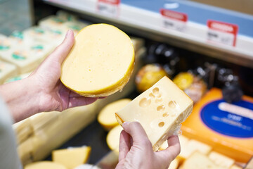 Buyer chooses cheese in store