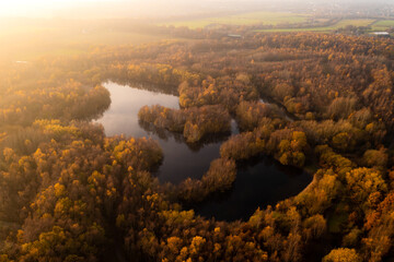 Obraz premium Aerial view above Walton Colliery Nature Park with Autumn woodland and lake in Wakefield