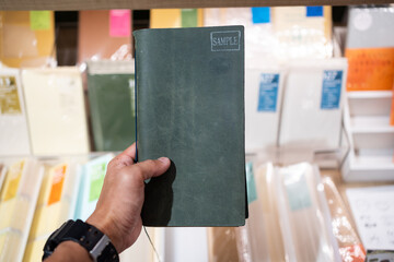 SINGAPORE - APR 19, 2022: Hand holding TRAVELLER’S notebook blue leather cover at Tokyu Hands...