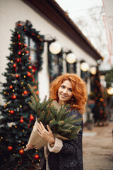 Woman with Christmas tree bouquet  in the city