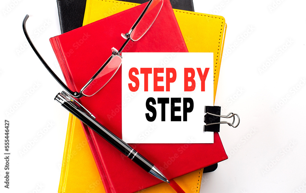 Poster step by step text written on a sticky on colorful notebooks