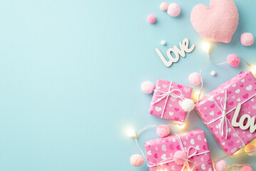 Valentine's Day concept. Top view photo of gift boxes light bulb garland soft heart shaped toy inscriptions love and fluffy pompons on isolated pastel blue background with empty space