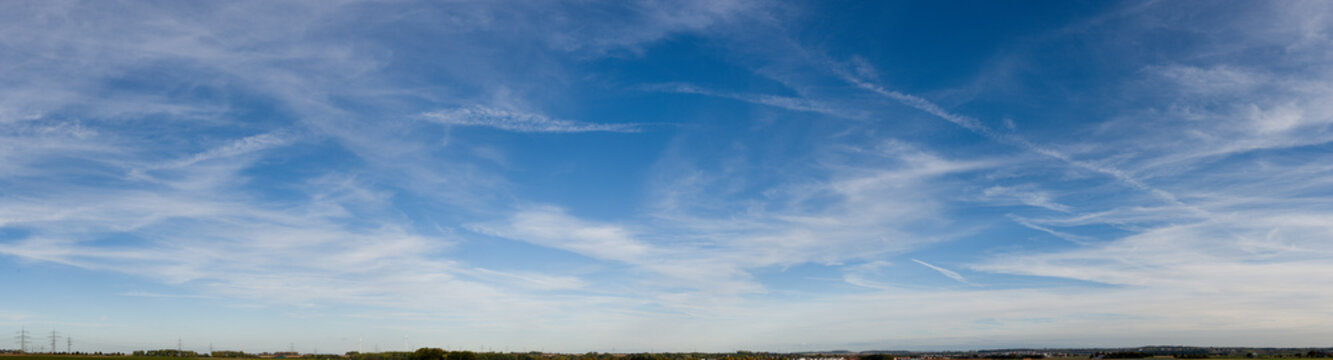 Blau-weißer Wolkenhintergrund mit Cirrostratuswolken und Kondensstreifen