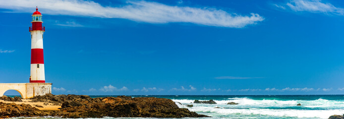 Colorful panoramic image of lighthouse over the rocks and sands  of the famous Itapua beach in the...