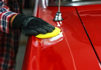 The man washing and cleaning the car. Detailing color polishing, hand holds the soft fiber sponge...