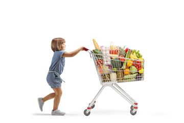Full length profile shot of a little girl pushing a big shopping cart
