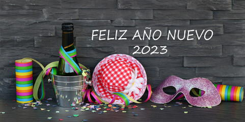 Una botella de vino espumoso con serpentinas y suministros para fiestas con el texto Feliz Año...
