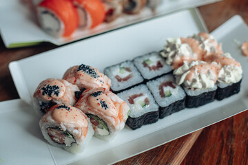 Beautiful delicious sushi. Sushi delivery. Advertising sushi rolls made of fish and cheese.