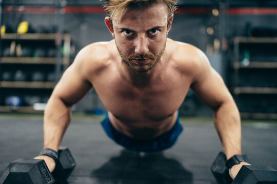 Close up photo of a concentrated man doing push-ups