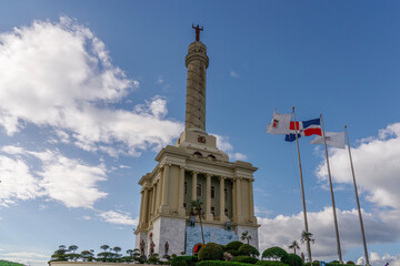 Independence Monument in Santiago against the backdrop of the flag of the Dominican Republic.
