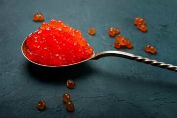 Spoons with red caviar, imitation, on a dark background, no people,