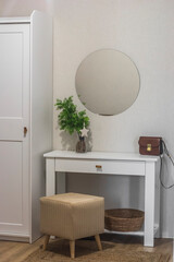 The interior of the hallway - wardrobe, mirror on the wall, console table, ottoman. Scandinavian light simple style