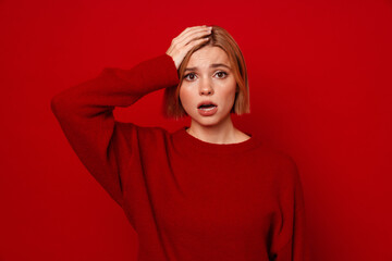Confused woman touching her head and looking at camera isolated