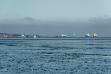 Gefrorenes Wasser in der Kieler F&ouml;rde an einem Sonnigen kalten Wintertag Frachtschiffe fahren zur Schleuse des Nord-Ostsee-Kanals