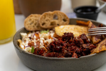mexican breakfast, chilaquiles with egg and toasted bread, chorizo de un costado deep dish