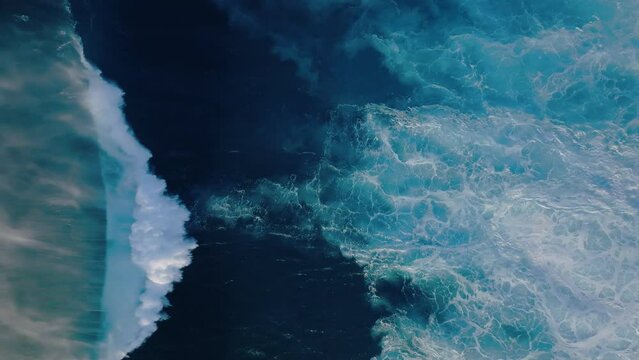 Top down abstract aerial view of ocean wave textures background crashing on sunny day
