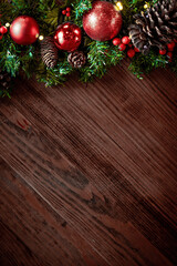 Christmas decorations and fir branches on wooden board background with copy space. Wooden new year background, wooden surface, green tree, red berries