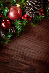Christmas decorations and fir branches on wooden board background with copy space. Wooden new year background, wooden surface, green tree, red berries