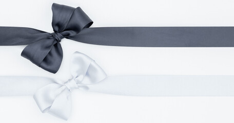 Nœuds de ruban de satin pour paquet cadeau de couleurs gris et blanc, isolé sur du fond blanc....