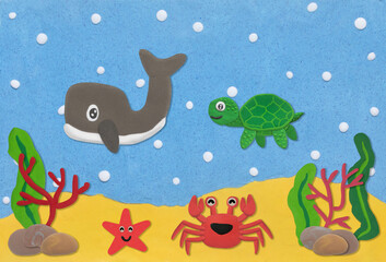 happy sea life animal made from plasticine on sand and sea under water background