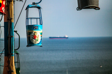 Fototapeta na wymiar Cabin of the cable car against the background of the ship of the sea and sky 
