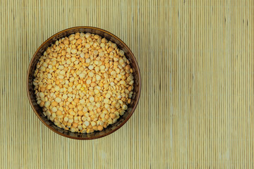 Pea in in bowl on a straw background. Vegetarian organic product. Vintage view. Top view. Copy space.