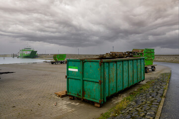 Open containers and skip bins stacked together awaiting transport by ferry
