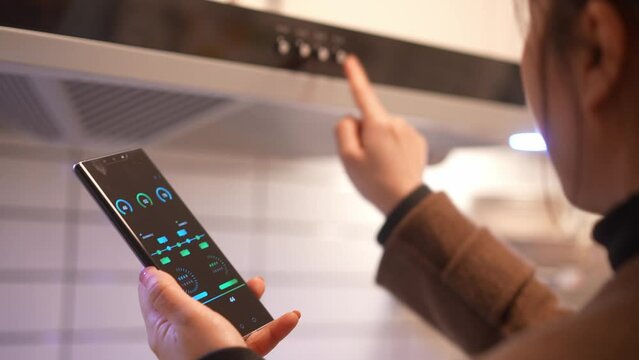 young female using mobile phone to control extractor