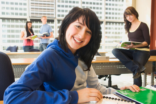 Female Student Foreground, Group Of Students In Background, In Fron Of Solar Panelled Windows, Winnipeg, Canada.