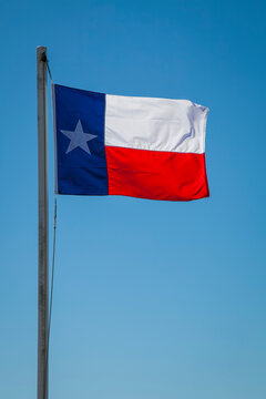 Texas state flag in a blue sky; Galveston, Texas, United States of America