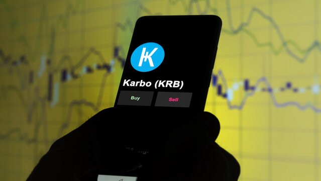 November 3th 2022, Roma. An investor's analyzing the Karbo (KRB) coin on screen. A phone shows the crypto's prices to invest