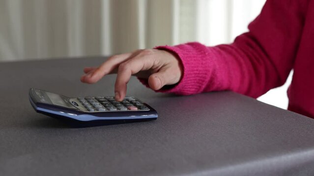 Time lapse woman's hand calculating on calculator