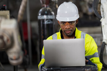 Male engineer worker using laptop computer working in the workshop in workshop. Male worker working with laptop computer in the factory. Industry manufacturing technology