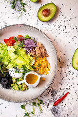 salad with tuna, olives and other ingredients on a white plate