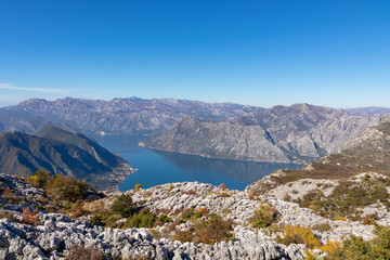 Obraz premium Panoramic view from Pestingrad (Derinski Vrh) of Kotor bay in sunny summer, Adriatic Mediterranean Sea, Montenegro, Balkan Peninsula, Europe. Fjord winding along coastal towns. Lovcen, Orjen mountains