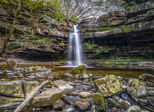 Summerhill Force is a picturesque waterfall in a wooded glade in Upper Teesdale. Heavily undercut, the recess behind the fall is known as 'Gibson's Cave'; Newbiggin, County Durham, England