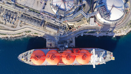 Aerial drone top down photo of LNG (Liquified Natural Gas) tanker anchored in small gas terminal...