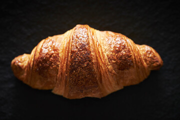 Croissant close-up, bread on black background