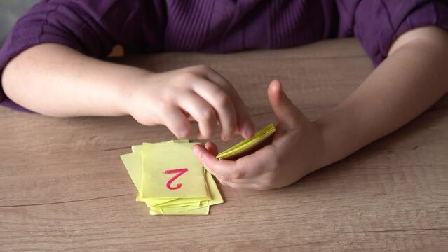 little girl plays in the store, weighs vegetables on a toy scale, and studies the numbers, close-up, the concept of children's home learning games