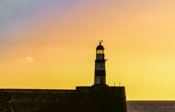 Lighthouse with golden sky at sunset; Seaham, Durham, England