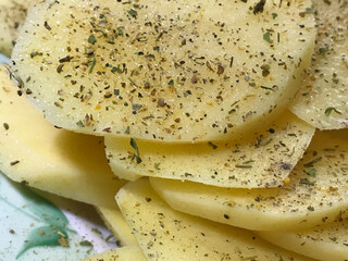 raw potatoes sprinkled with seasonings, cut into round pieces for boiling and baking