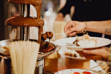 Tremper les fruits dans la fontaine de chocolat
