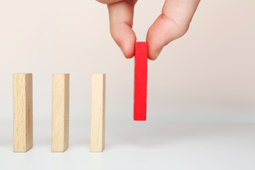 The hand puts dominoes to make a chain reaction