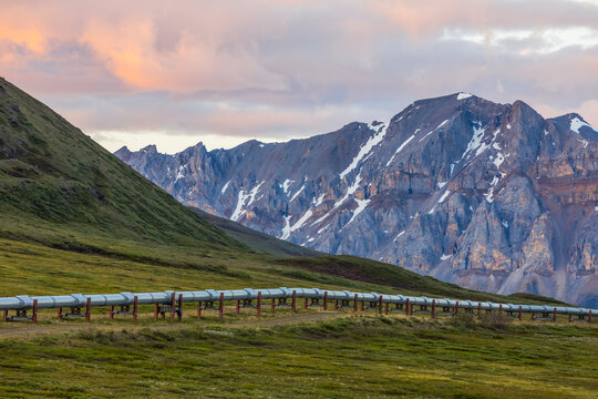 The Trans-Alaska Pipeline stretches across the tundra beneath the craggy mountains of the Brooks Range; Alaska, United States of America