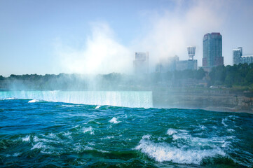 Niagara Falls Summer Travel Landscape Series, view of Canadian Side Skyline and steam rising from Horseshoe Falls from US side state park in New York, USA