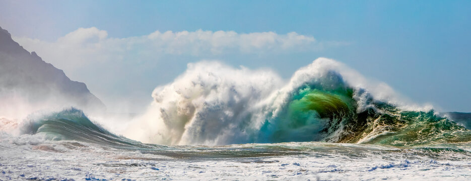 Large ocean wave crashes into rock along the Na Pali Coast; Kauai, Hawaii, United States of America